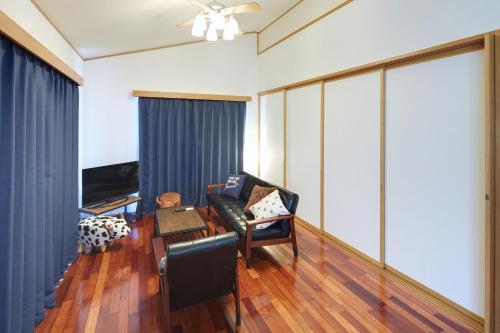 a living room with a couch and a table at Casa de R in Motobu