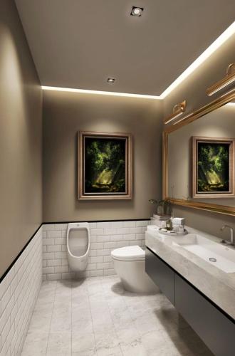 a bathroom with a toilet and a sink and a mirror at Siam Bright Suite in Bangkok