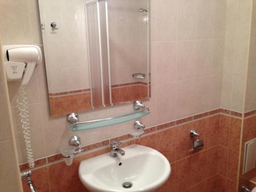 a bathroom with a sink and a mirror at Royal House Apartments TMF in Pamporovo