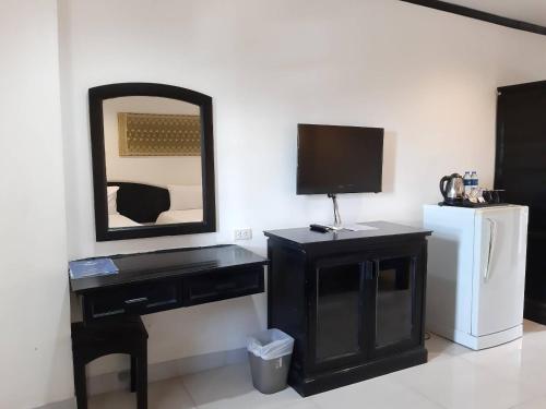 Habitación con escritorio negro, TV y espejo. en Golden Tulip Essential Pattaya en Pattaya North