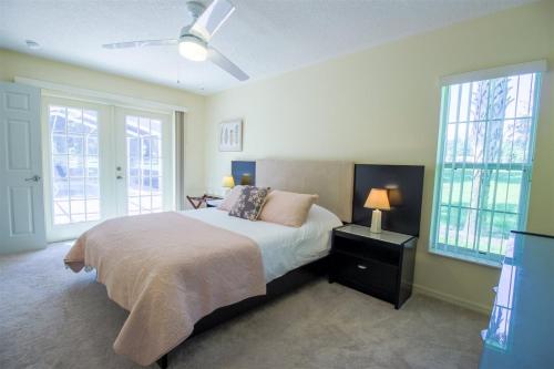 ein Schlafzimmer mit Bett und Deckenventilator in der Unterkunft Hernando 4BR-3BA Private Pool Oasis in Hernando