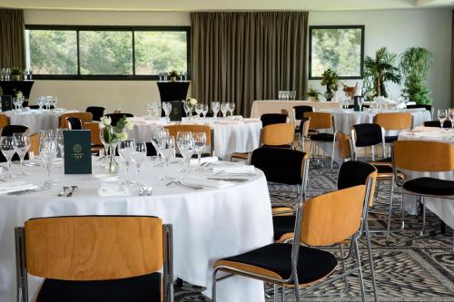 a banquet room with white tables and chairs at Best Western Plus Hotel les Rives du Ter in Larmor-Plage
