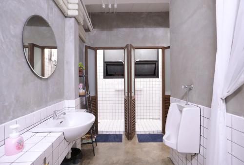 a bathroom with a sink and a toilet and a mirror at Apartment45 Hostel in Bangkok