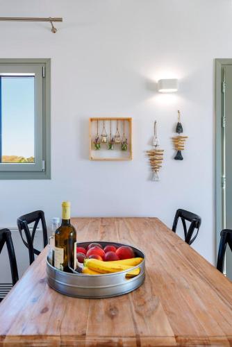 a bowl of fruit and a bottle of wine on a table at Aelion Villa in Vari