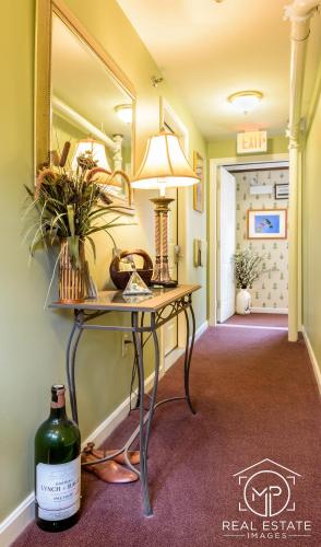 a hallway with a table with a lamp and a mirror at Bouchard Restaurant & Inn in Newport