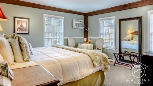 a bedroom with a large bed and a mirror at Bouchard Restaurant & Inn in Newport