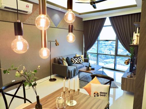 a living room with lights hanging from the ceiling at Azure Residences by Sleepy Bear Paradigm Mall in Petaling Jaya