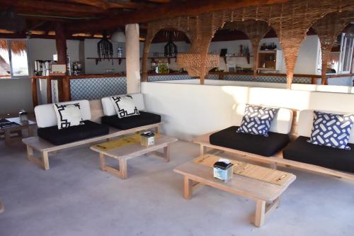 a living room with couches and tables in a room at Spirit Holbox in Holbox Island