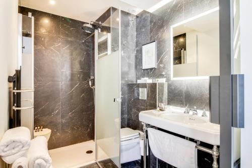 a bathroom with a shower and a sink and a toilet at Mom'Art Hotel in Paris