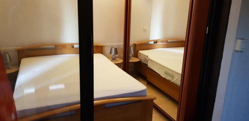 - 2 lits dans une petite chambre avec un miroir dans l'établissement Residence Caroline T2 clim parking, à La Grande Motte
