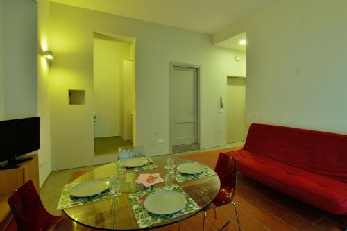 a living room with a glass table and a red couch at Rosalmar B&B in Palermo