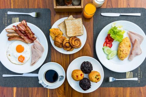 a table with three plates of breakfast foods and a cup of coffee at Sevenseas Resort Koh Kradan in Koh Kradan