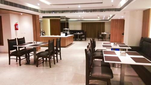 a restaurant with tables and chairs and a bar at Hotel Smart City Park Inn in Tada