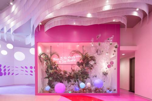 a pink wall with a bunch of plants on it at Lakeshore Hotel Yilan in Yilan City