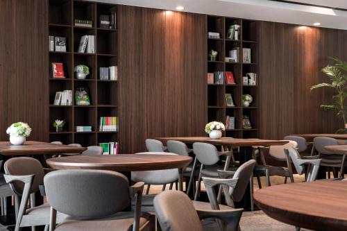 a library with tables and chairs and bookshelves at Lakeshore Hotel Yilan in Yilan City