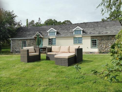 a house with two couches sitting in the yard at Lletty Ann wynn at Fraithwen Cottages in Newtown