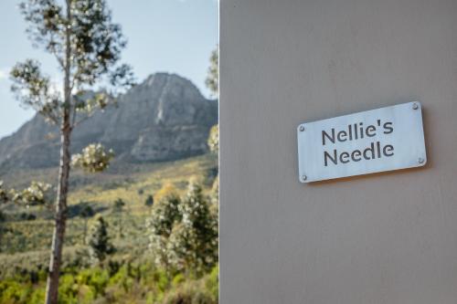a sign on a wall that reads neills needle at Opstal Stay in Rawsonville