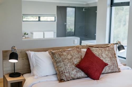 a bedroom with a bed with pillows on it at Opstal Stay in Rawsonville