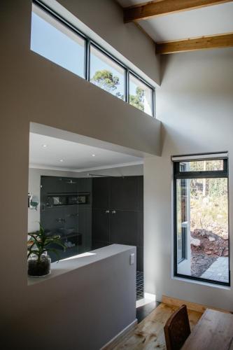a bathroom with a large window and a large mirror at Opstal Stay in Rawsonville