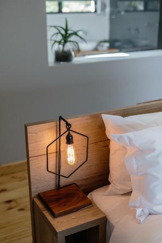 a light on the headboard of a bed at Opstal Stay in Rawsonville