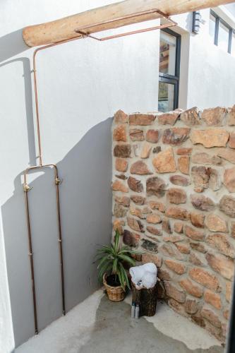 a stone wall with a plant next to it at Opstal Stay in Rawsonville