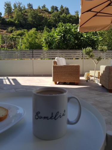 a coffee mug sitting on a table with a plate of food at Evmelia Kakopetria Suites in Kakopetria