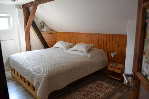 a bedroom with a large bed with a wooden headboard at Apartman75 in Tišnov