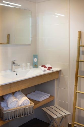 une salle de bain avec un lavabo, un miroir et des serviettes dans l'établissement La Maison De Siloe, à Villefranche-de-Rouergue