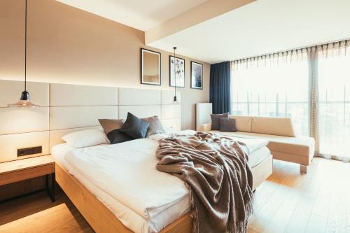 a bedroom with two beds and a large window at Hotel Kowald Loipersdorf in Loipersdorf bei Fürstenfeld