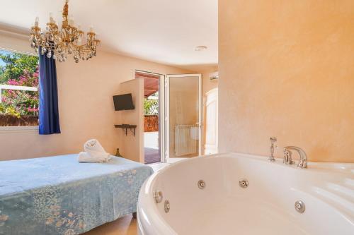 een badkamer met een bad, een bed en een kroonluchter bij Torre Sabea in Gallipoli