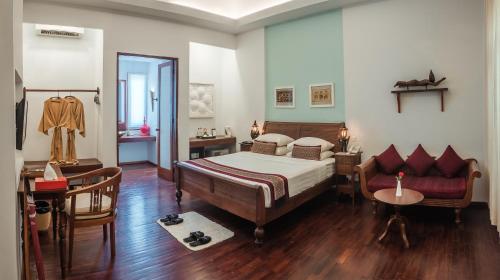 ein Schlafzimmer mit einem Bett, einem Tisch und einem Sofa in der Unterkunft Areindmar Hotel in Bagan