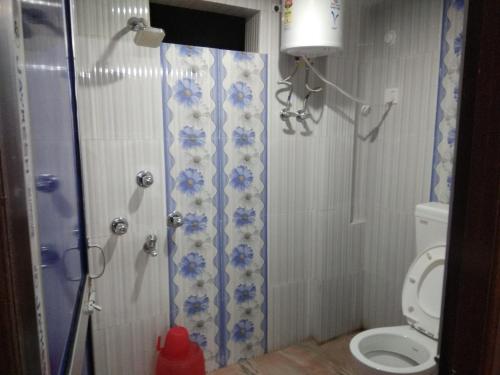 a bathroom with a shower and a toilet at Babusona Homestay in Jaldapara in Mādāri Hāt