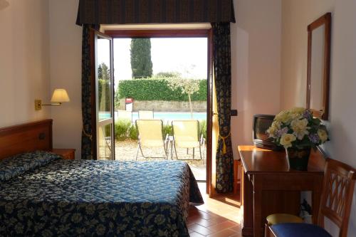 a bedroom with a bed, table and window at Hotel Villa Dei Bosconi in Fiesole