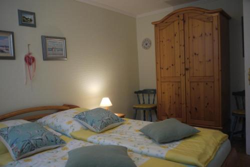 1 dormitorio con 2 camas y armario de madera en Gieske, en Westerland