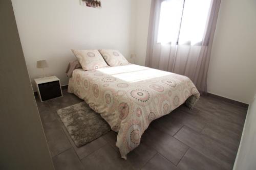 1 dormitorio con 1 cama con manta rosa y ventana en Coin Zen et Reposant, en Le Tampon