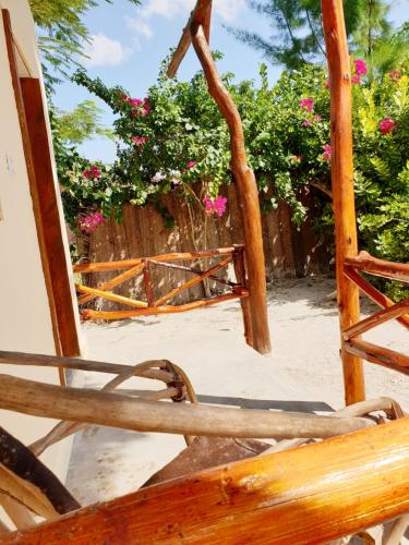 an open door to a gate with pink flowers at Michamvi Spirit Lodge in Michamvi
