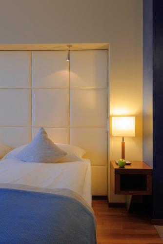 a bedroom with a bed and a table with a lamp at Radisson Blu Hotel, St. Gallen in St. Gallen