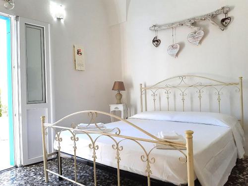 ein Schlafzimmer mit einem weißen Bett mit Herzen an der Wand in der Unterkunft B&B Antiche Stelle Salento in Salve