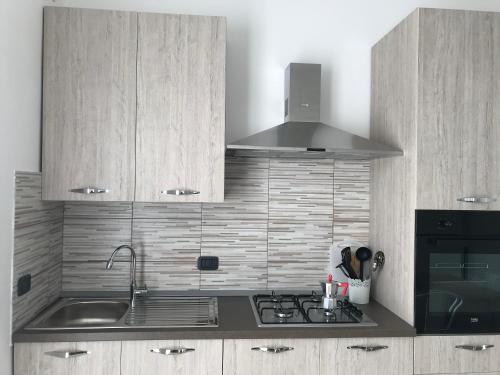 a kitchen with a sink and a stove top oven at La Terrazza sul Mare in Palmi