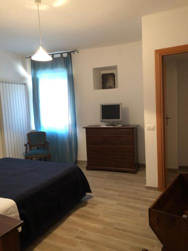 a bedroom with a bed and a television on a dresser at Il Minotauro B&B a 5 minuti da Popoli in Vittorito