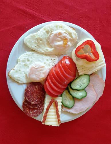a plate of food with eggs and vegetables on a table at Pensiunea Sarah Bran in Bran