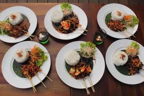 a group of plates of food on a table with chopsticks at Swiss-Belinn Modern Cikande in Serang