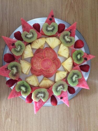 a plate with kiwis and fruit on a table at Paarl Mountain Lodge in Paarl