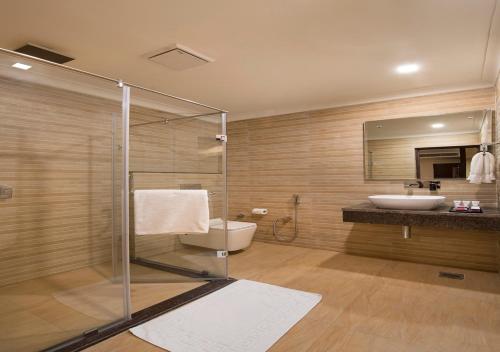 a bathroom with a shower and a toilet and a sink at Clarks Inn Suites Katra in Katra