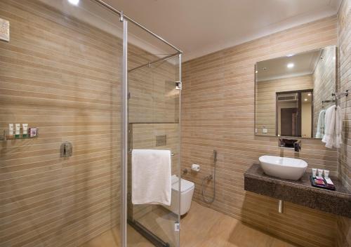 a bathroom with a toilet and a sink and a shower at Clarks Inn Suites Katra in Katra