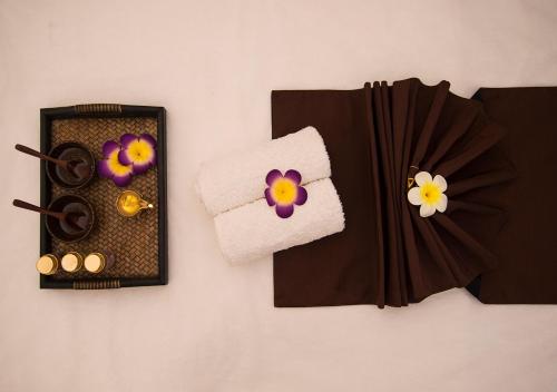 a bathroom with a towel and some flowers on a wall at Clarks Inn Suites Katra in Katra