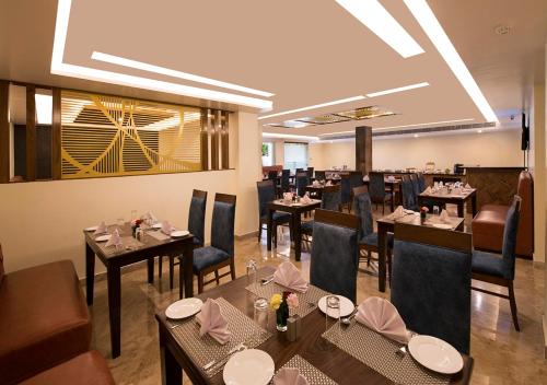 a dining room with tables and chairs and a restaurant at Clarks Inn Suites Katra in Katra