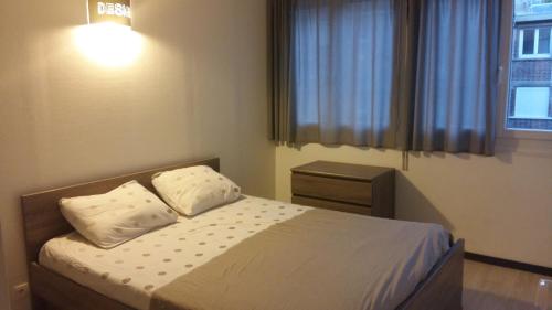 a bedroom with a bed with two pillows and a window at Appartement Le Tréport Centre in Le Tréport