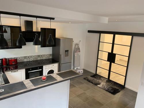 a kitchen with a stove and a refrigerator at Manifique Maison T2 50m2 Atypique wifi & parking privée in Oullins