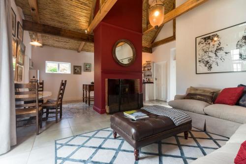 a living room with a couch and a fireplace at Bartinney Private Cellar Banhoek in Stellenbosch
